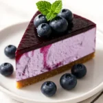 slice of blueberry mousse cake served with berries
